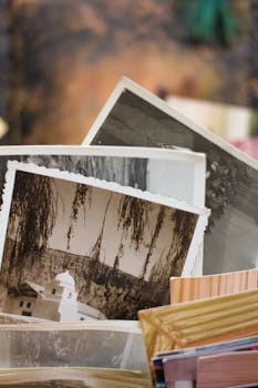 Close-up of a stack of vintage photographs displaying historic scenes.